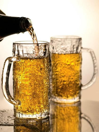 A classic beer pour shot. The golden liquid fills a frosty mug, creating a dynamic and refreshing image that is perfect for any beverage brand looking for enticing visuals.