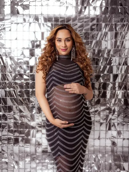 A confident frontal pose, showing off the bump in this unique, glittering gown.