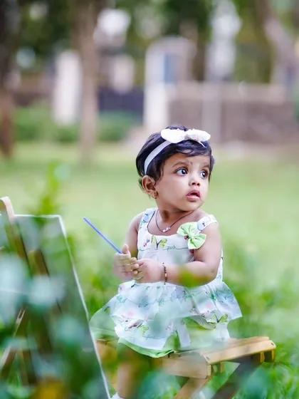 A little artist at work. This creative pre-birthday shoot in a park uses a miniature easel and paintbrush to capture a child's curious spirit.