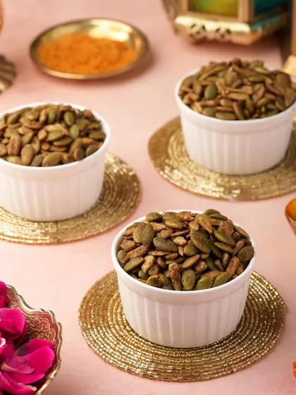 Roasted pumpkin seeds, a healthy addition to a festive hamper. The golden coasters and props continue the celebratory theme.