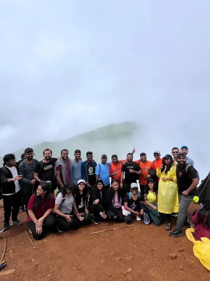 The group gathered on the trail, with the misty peak of Nethravathi visible in the background.