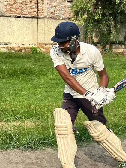 A batsman getting into position to play a powerful drive. A strong stance and balance are the foundation of good batting, which we emphasize in our coaching.