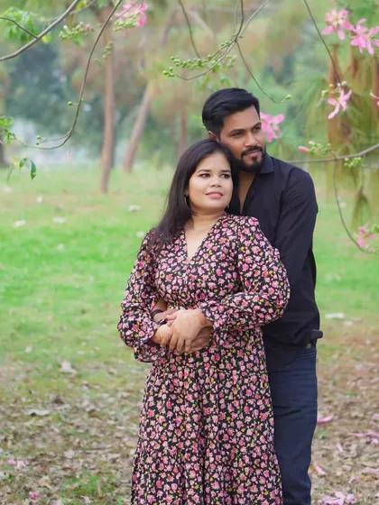 A tender moment captured during a couple's pre-wedding shoot, with the groom embracing the bride-to-be from behind in a serene, natural environment.