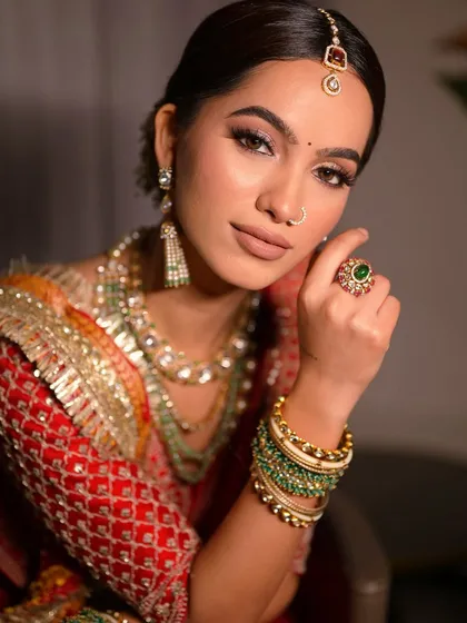 This portrait highlights the beautiful symmetry of the makeup and the elegance of the jewelry. The matte lipstick and defined eyes create a powerful and timeless bridal look.