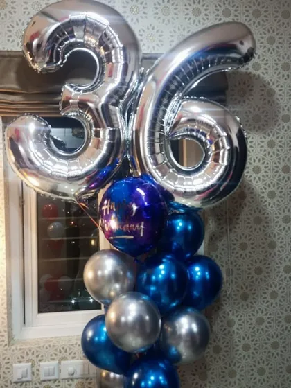 This striking balloon bouquet was designed for a 36th birthday. It features large silver number foils above a base of metallic blue and silver chrome balloons, perfect for a modern and stylish celebration.