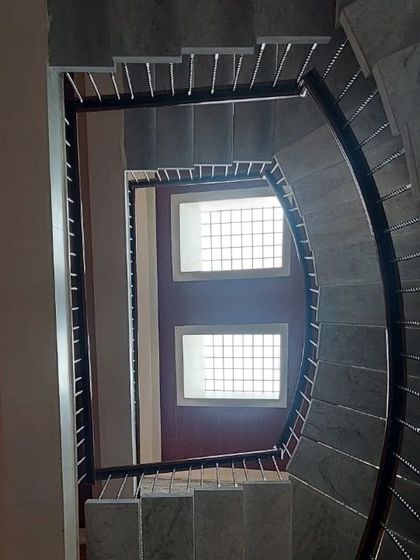 A worm's-eye view of a square staircase, showing the geometry and the skylights that illuminate it from above.