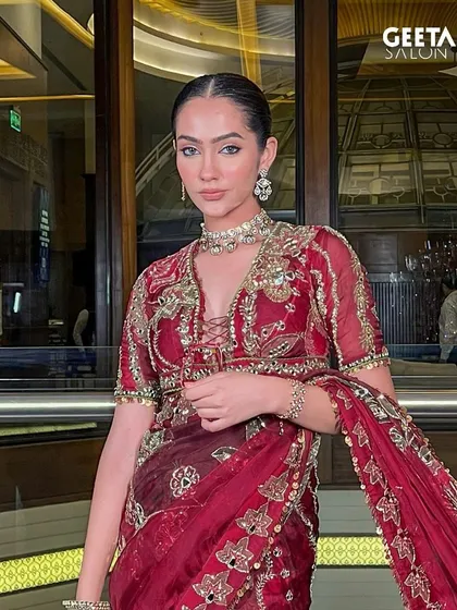 A complete bridal portrait. The rich, embroidered saree is paired with a sleek, center-parted bun and makeup that radiates a timeless glow, perfect for a classic wedding ceremony.
