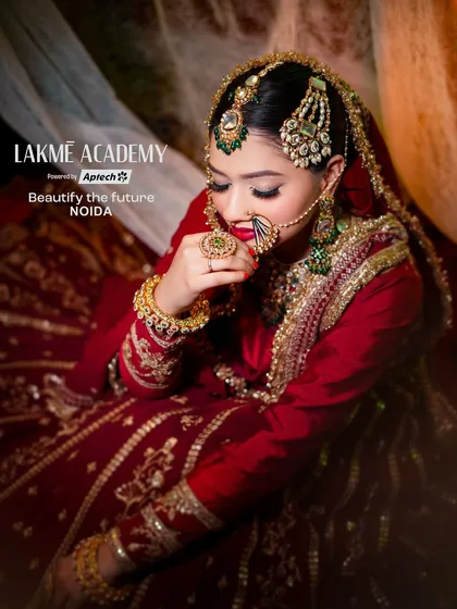 A stunning Muslim bridal look, rich in color and tradition. This portrait highlights the deep red outfit, intricate gold embroidery, and the classic passa (jhumar) jewelry.