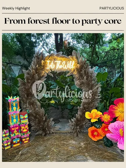 From forest floor to party core. Our 'Into the Wild' tribal-themed setup was a highlight, featuring a neon sign, pampas grass arch, and colorful tiki-style props.
