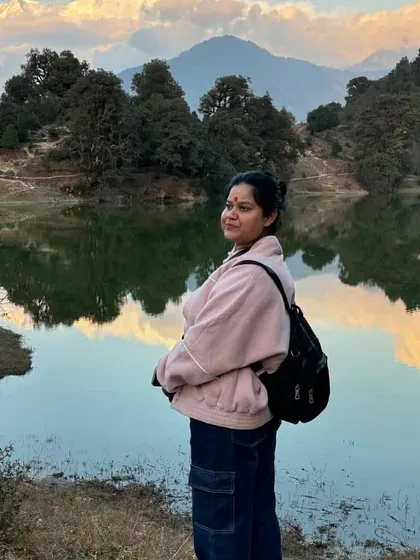 Taking in the stunning view at Deoria Tal, with the mountains reflected in the water. It's the perfect spot for your next profile picture.