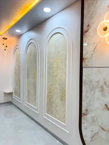 This image shows the decorative wall treatment I created for a living room. It features three arched panels with a textured paint finish, framed by POP moulding to add a touch of classic elegance.