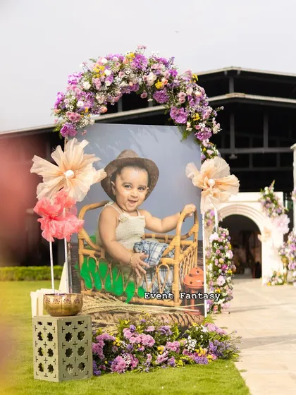 Another adorable photo cutout from Dhanvith's celebration, decorated with a floral arch. Placing these along the entrance path creates a fun and personalized welcome.