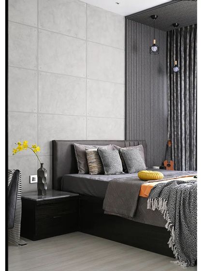 The corner of the grey-themed bedroom reveals layers of texture. A fluted panel wall adds vertical interest next to the bed, while industrial-style pendant lights hang down, providing focused light and contributing to the modern aesthetic.