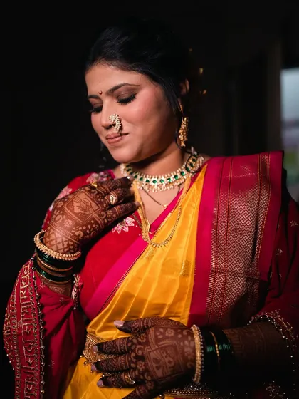 A full portrait showcasing the glam yet traditional brown smokey eyes, which pair beautifully with the yellow and red saree.