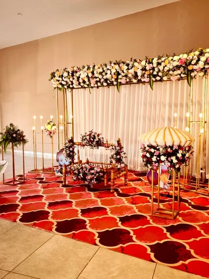We designed this grand and traditional naming ceremony with a beautiful floral theme. The setup includes a flower-adorned cradle, a backdrop of white drapes and a dense floral runner, and warm lighting to create a classic, welcoming atmosphere.