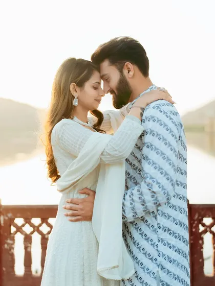 A warm, sun-kissed portrait of the couple in a close embrace, with the golden hour light creating a romantic glow.