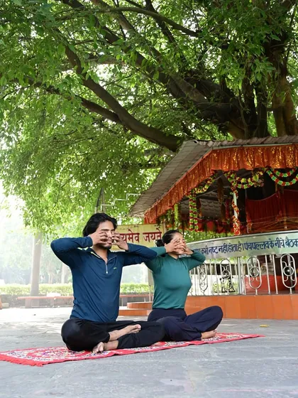 An outdoor partner pranayama session. Practicing together in nature enhances the calming benefits of the breathing exercises.