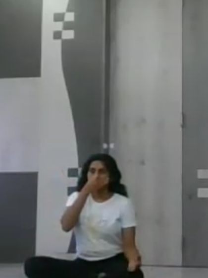 An instructor demonstrates Nadi Shodhana (Alternate Nostril Breathing) in a virtual session. This pranayama technique is fundamental for balancing energy and calming the mind, and we teach the correct hand mudra and breathing pattern.