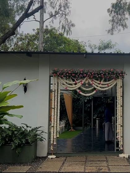 The entrance to the engagement ceremony is decorated with beautiful garlands of jasmine and roses, offering a warm and fragrant welcome to all the guests.