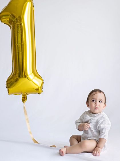 "Wait... I'm ONE already?!" This little one looks so surprised and cute next to his giant number one balloon.