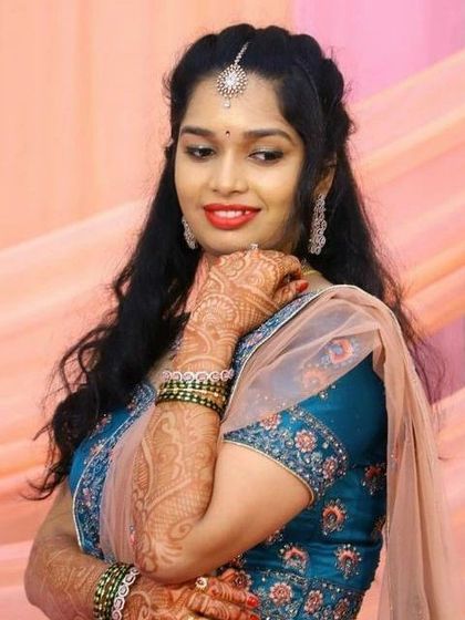 This bride is glowing in her reception lehenga. The makeup is kept elegant and radiant, with a focus on her smile and intricate henna design.