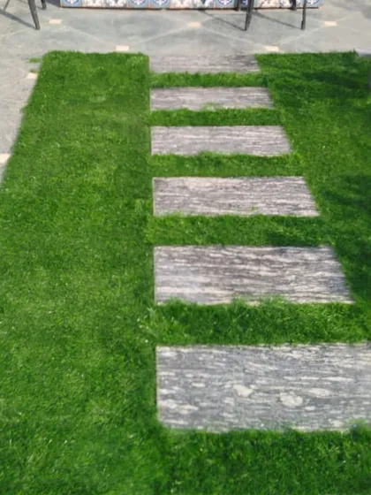 A close-up of the stone path and artificial grass combination. This design is practical and adds great visual texture to a terrace floor.