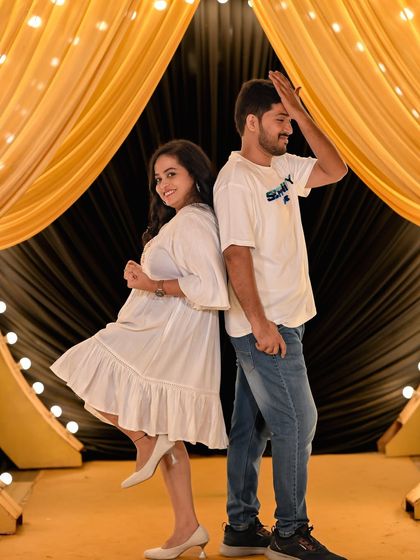 A playful and candid moment against a stage-like backdrop with golden curtains.