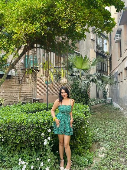 A full, front-facing shot of the green romper. This clearly shows the design and fit of the playful outfit.