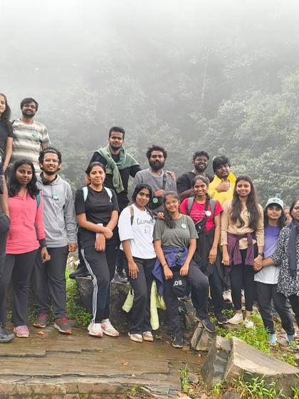 A group photo on a rocky outcrop, with the misty forest behind them.