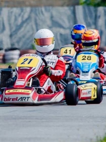 A tight pack of three karts, with our Birel ART driver number 21 holding the inside line to defend their position.