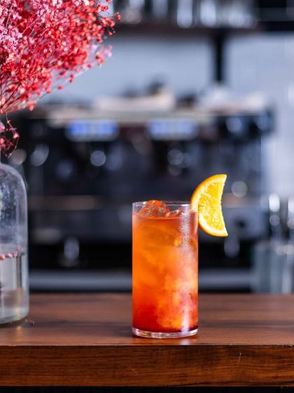 Kickstart the weekend with some fabulous drinks. An Americano-style cocktail sits on the bar, ready for a guest.
