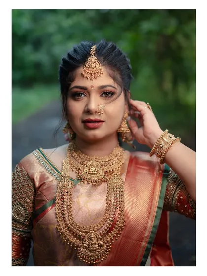 An elegant South Indian bridal portrait showcasing the intricate details of temple jewellery, a silk saree, and flawless makeup, representing timeless heritage.