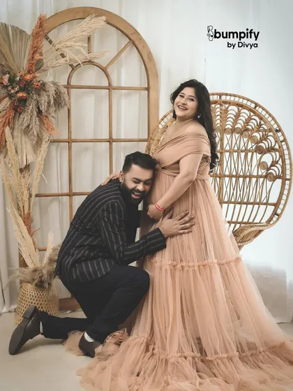 The dad-to-be joins in for a sweet and playful moment, listening to the baby bump. This is a favorite pose for many couples during their boho-themed maternity shoot.