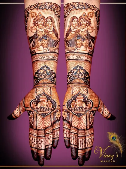 A traditional bridal design featuring Radha Krishna figures on the forearms. The palms are adorned with palace motifs, creating a beautiful blend of divine and royal themes.