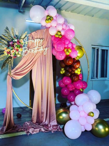 This is a duplicate of ID 142, 167, 199. A beautiful circular backdrop with pink drapes and a vibrant balloon arrangement. This setup combines soft fabrics with bright balloons for a sophisticated and celebratory look.