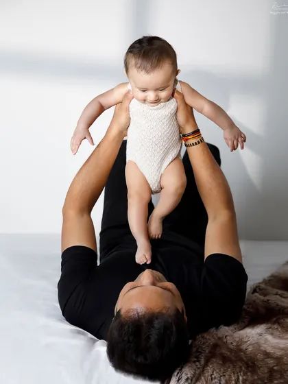 Playtime with dad. This fun shot of a father and baby playing on the bed captures the joyful, energetic side of their relationship.