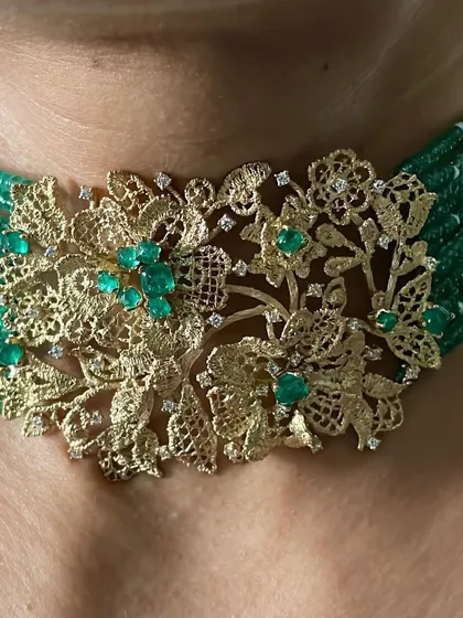 This is my handcrafted choker, created to feel like a piece of golden lace against the skin. Seen here on Janhvi Kapoor, it features a floral filigree design in 18k gold, set with natural diamonds and ethically sourced Zambian emeralds, and strung on a bed of emerald beads.