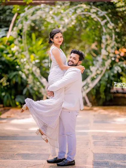 A playful and romantic moment with a couple in all-white outfits.