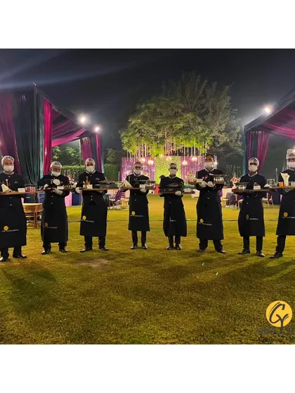 My team of servers lined up at an outdoor event, holding trays of appetizers and ready to begin service.