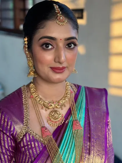 A close-up of the client, showing her elegant makeup and the beautiful color combination of her saree and blouse.