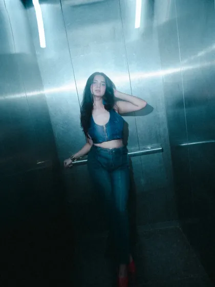 The lighting in this elevator shot creates such a cool, cinematic feel. My job is to make sure your outfit and pose work together to tell a story, even in the most compact spaces.