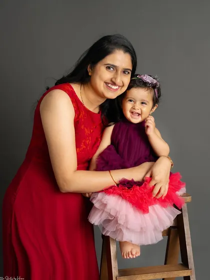 The pure joy on this little girl's face is everything. This mother-daughter portrait captures a moment of genuine laughter and happiness.