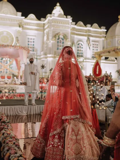 A bride's grand entrance is a story in itself. We capture this pivotal moment from a unique perspective, highlighting the magnificent venue, the traditional elements, and the groom's eager anticipation.