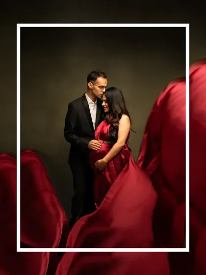 A romantic and dramatic couple's portrait. The flowing red fabric envelops the couple, creating an intimate and artistic image that focuses on their connection and anticipation.