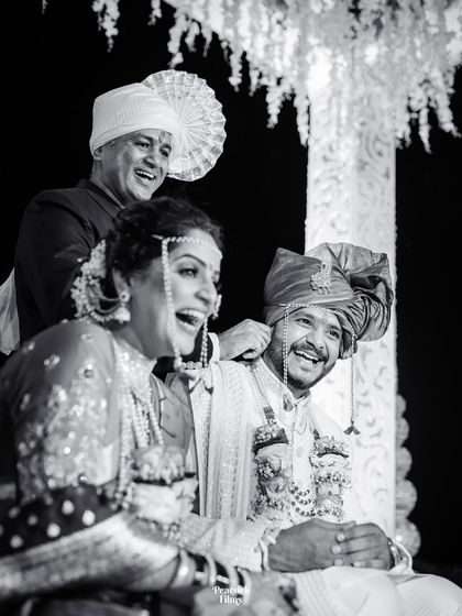 A moment of shared laughter between the couple and a family member during their wedding ceremony, captured in timeless black and white.