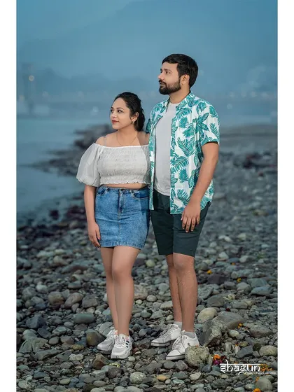 A casual, relaxed pose on the rocky riverbank. This photo captures a quiet moment of the couple just being themselves and taking in the scenery.