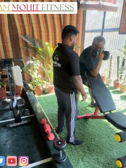 An elderly client performing bicep curls on a preacher bench at his home gym. I cater to clients of all ages, helping them stay strong and active.