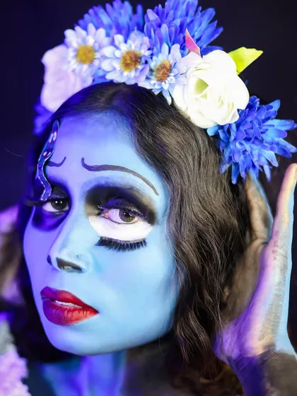 A close-up of the Corpse Bride's face, highlighting the large, expressive eyes and a custom-made floral headpiece.