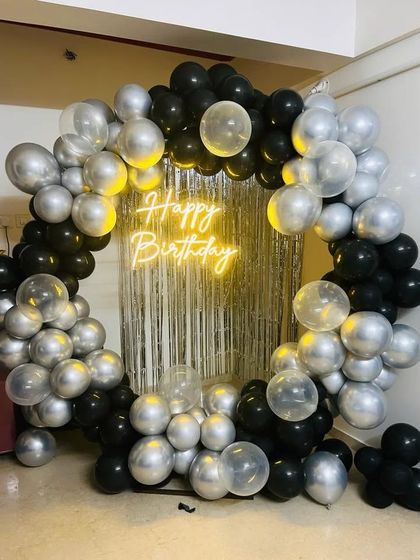 A sleek and modern black and silver balloon ring, perfect for a stylish and contemporary birthday party. The silver fringe curtain adds extra texture and shine.