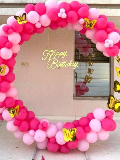 A simple and bright pink butterfly-themed balloon ring. This setup is perfect for a cheerful and fun birthday photo corner at home.